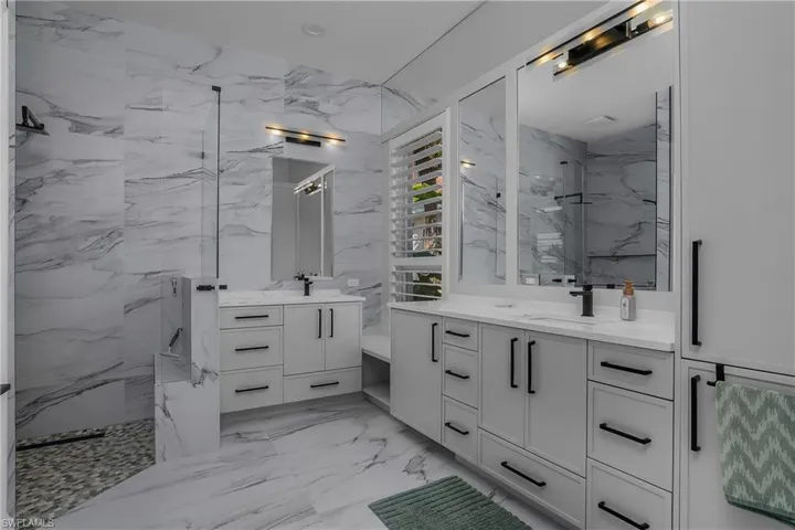 Master bath with frameless shower and quartz counters. Additional storage is provided by custom cabinetry in the toilet room. Entire house is air-conditioned and heated by a new 2026 Trane heat pump system.