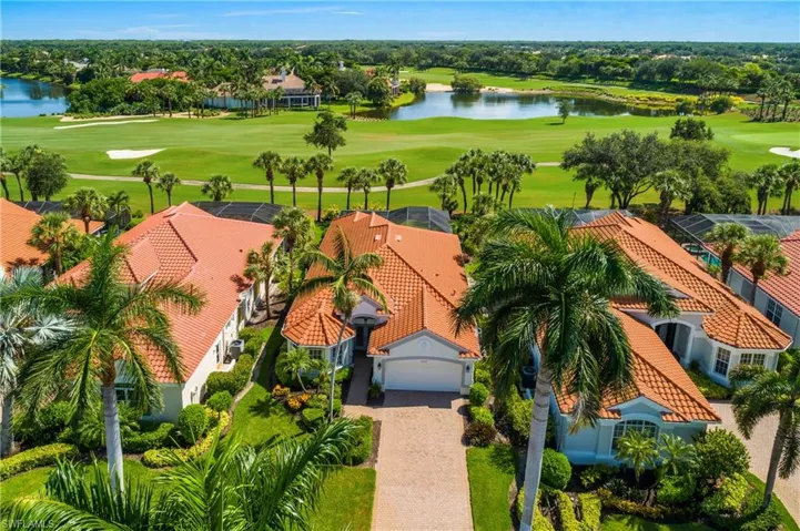 Aerial drone view of house frontage embraced by stately Royal Palms and lanai views.