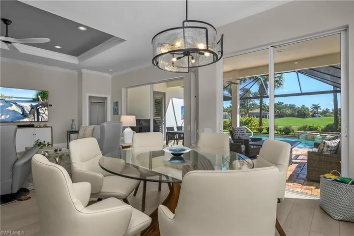 View from dining area to lanai, pool and spa and fairway #6 of Shadow Wood's south course beyond.