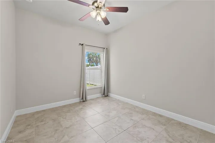 Spare room featuring ceiling fan and light tile floors
