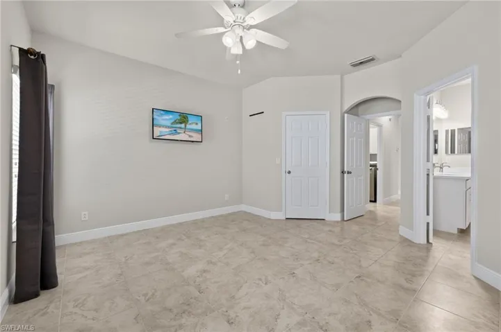 Unfurnished room featuring sink, ceiling fan, and light tile floors
