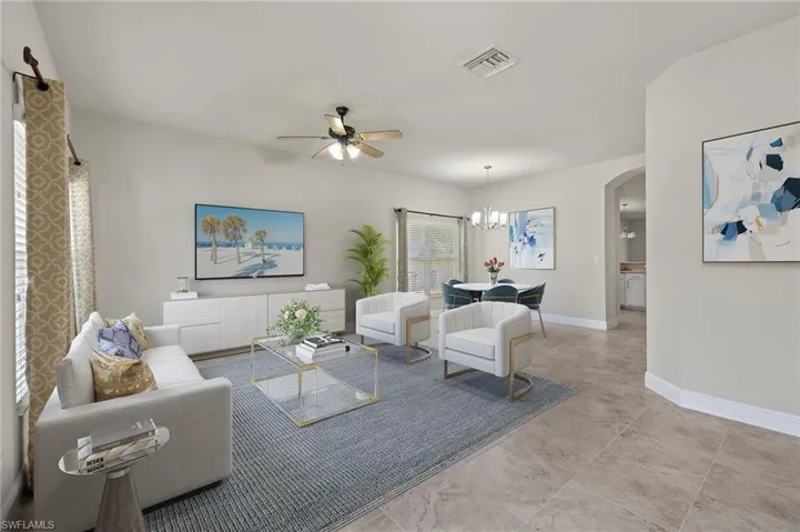 VS- Living room with light tile floors and ceiling fan with notable chandelier