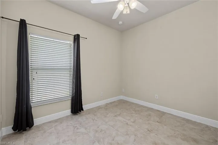 Tiled spare room with ceiling fan and a wealth of natural light