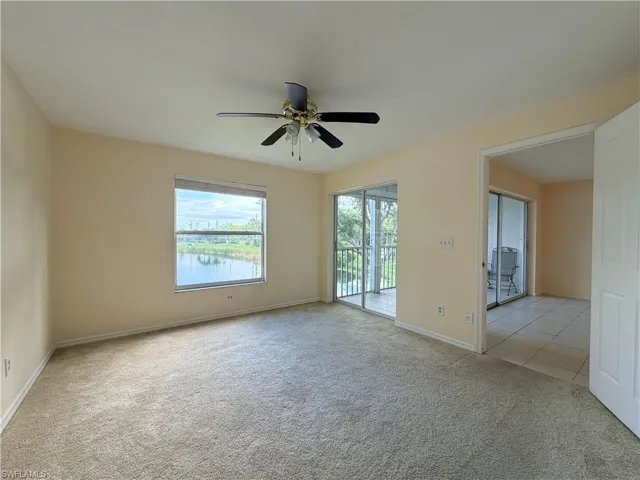 Spacious room featuring carpet flooring, a ceiling fan, and ample natural light from a large window