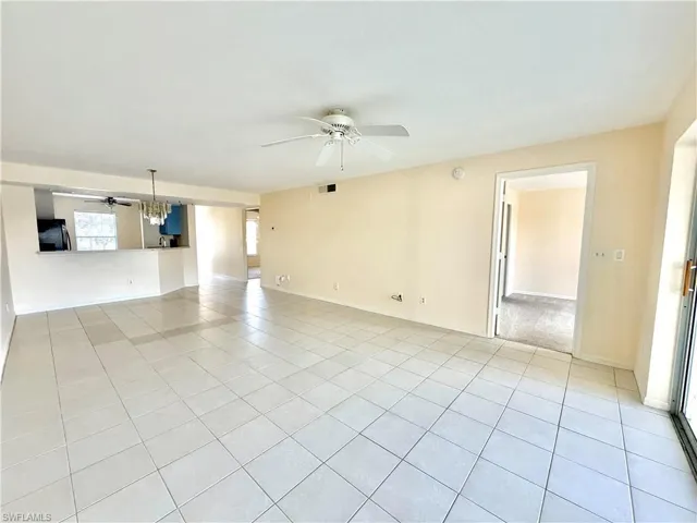 Spacious room featuring tile flooring, a ceiling fan, and light-toned walls