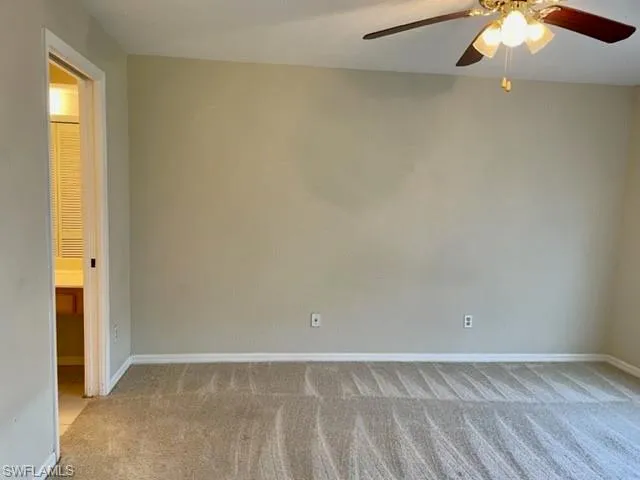 Empty room with light carpet and a ceiling fan