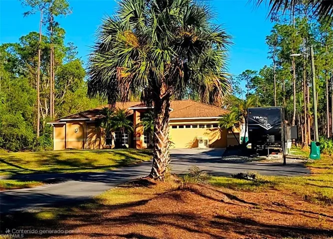 View of front facade featuring a garage and a front yard