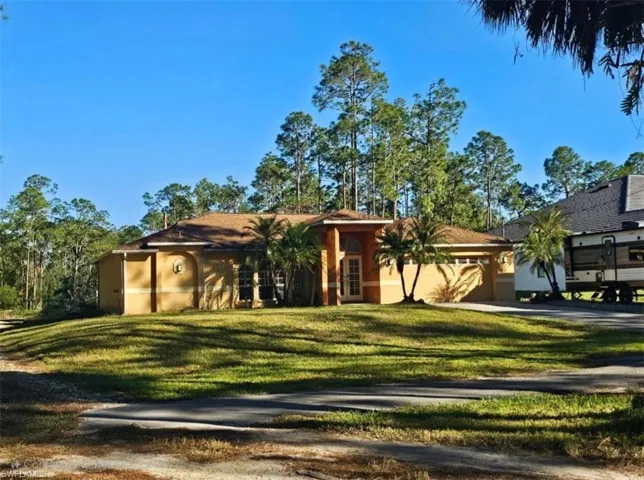 North side of the home featuring a front yard, garage and access road to the back yard