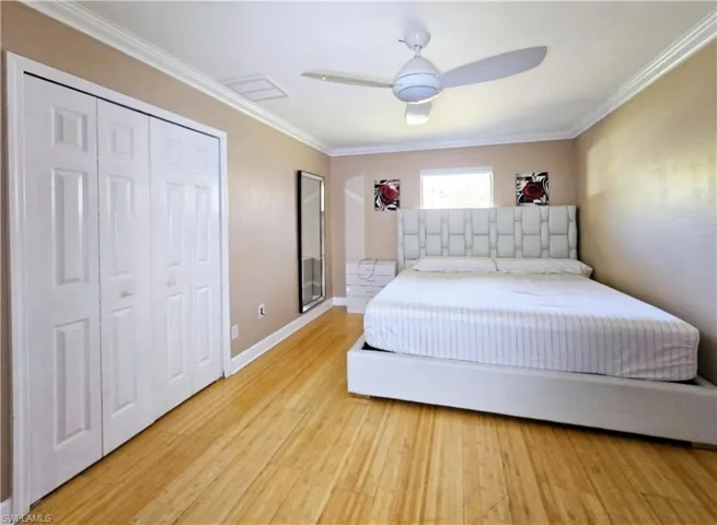 Second Bedroom featuring hardwood / wood-style flooring, ceiling fan, ornamental molding, and a closet