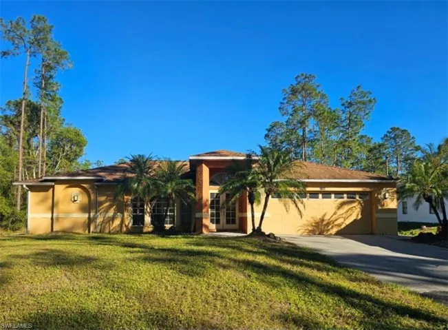 View of front facade featuring a front yard and a garage
