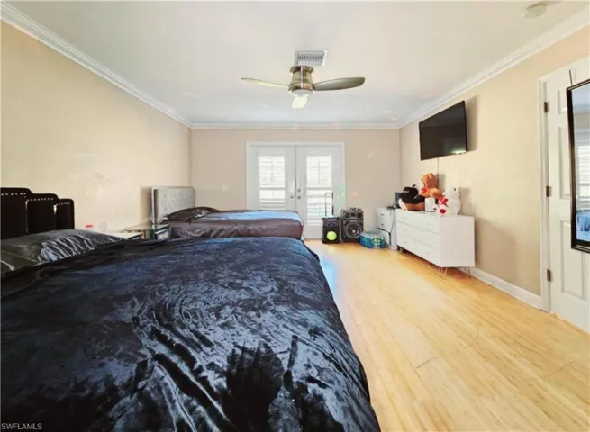 Master Bedroom with access to outside, french doors, crown molding, hardwood / wood-style flooring, and ceiling fan