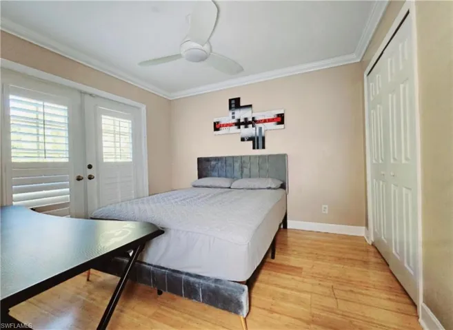 Third Bedroom featuring ceiling fan, light hardwood / wood-style flooring, crown molding, and french doors