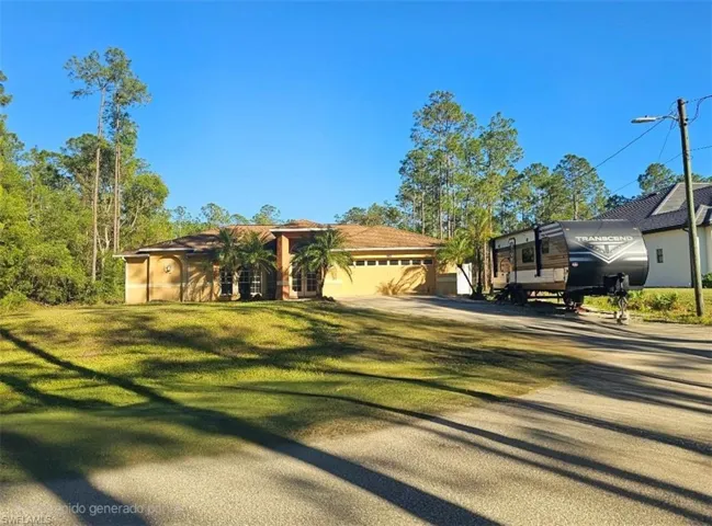 View of front of property with a front yard and a garage