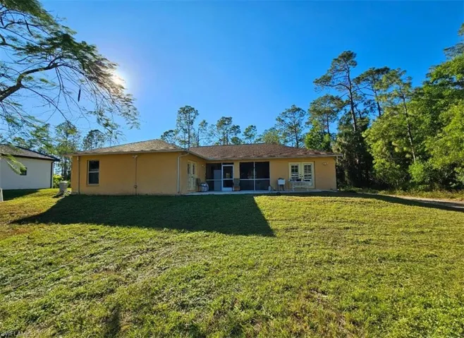 Back of house featuring a lawn