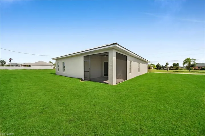 Back of property featuring a lawn