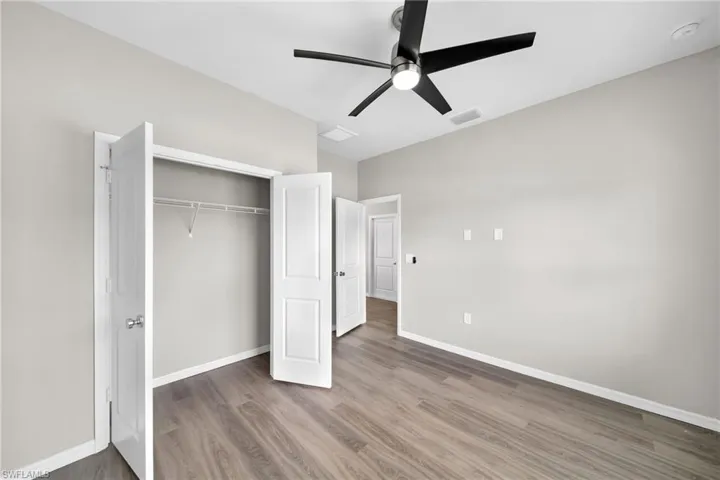 Unfurnished bedroom featuring ceiling fan, a closet, and wood-type flooring