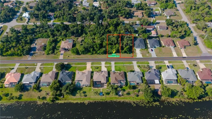 Expansive undeveloped lot featuring mature trees and direct road frontage