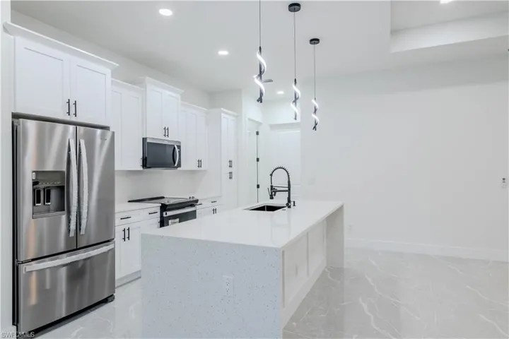 Kitchen with white cabinetry, recessed lighting, marble finish floor, a sink, and stainless steel appliances