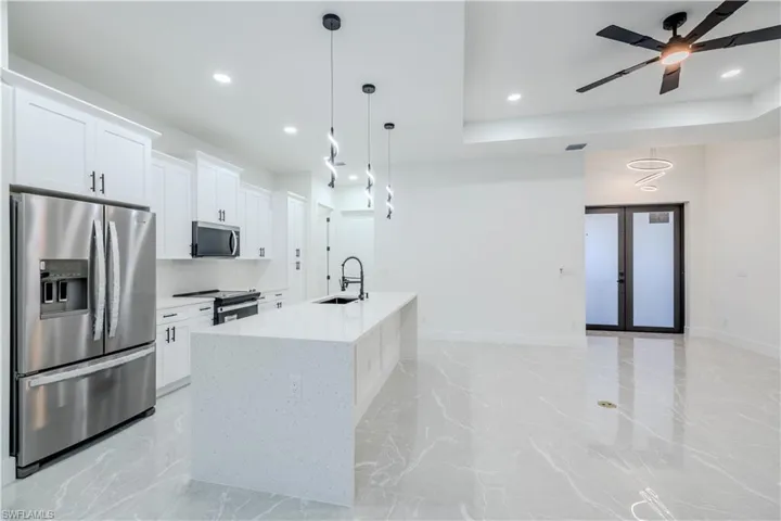 Kitchen with white cabinets, a sink, recessed lighting, stainless steel appliances, and marble finish floor
