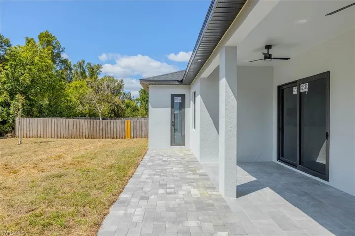 View of yard featuring a patio area, fence, and a ceiling fan