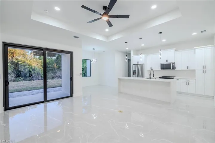 Kitchen featuring recessed lighting, white cabinetry, a tray ceiling, ceiling fan, and appliances with stainless steel finishes