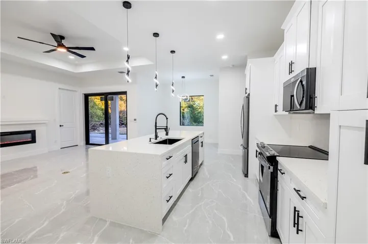 Kitchen featuring stainless steel appliances, recessed lighting, marble finish floor, and a sink