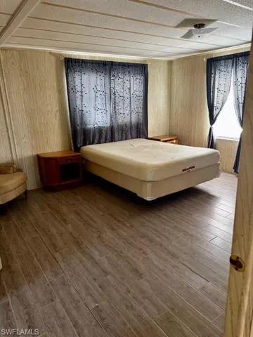 Bedroom featuring wooden walls and wood finished floors