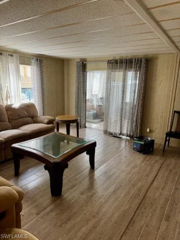 Living area featuring plenty of natural light, wood finished floors, and wood walls
