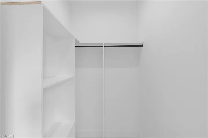 Integrated white shelving system with a built-in hanging rod, offering versatile storage