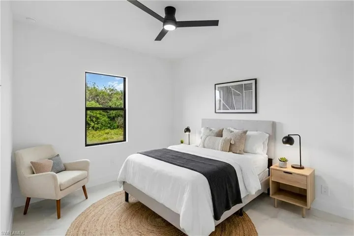 Virtually Staged.  Bright room featuring light-colored flooring and a black ceiling fan
