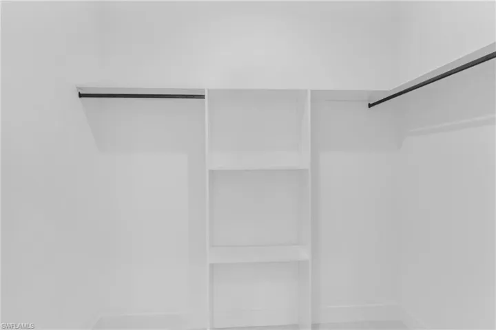 White closet system featuring built-in shelving and dual hanging rods
