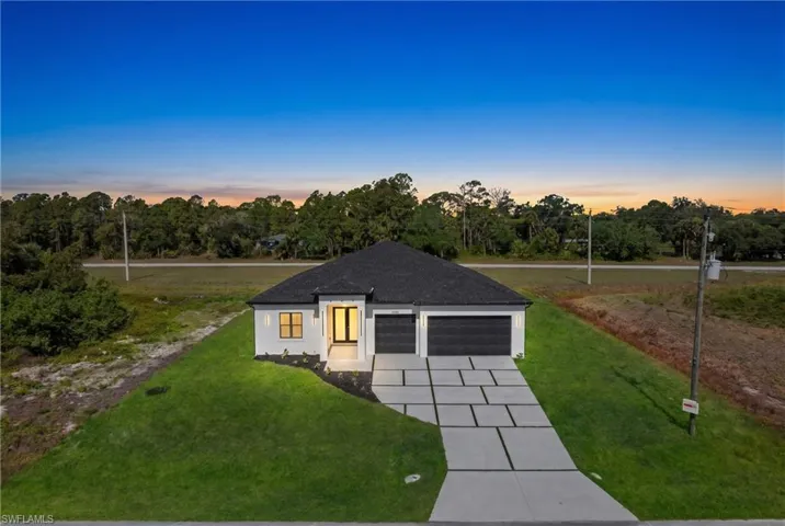 Modern single-story residence featuring a dark shingle roof and a light-colored exterior