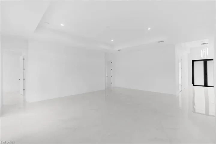 Spacious interior featuring pristine white walls and large format tile flooring