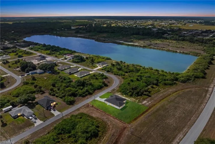 Aerial landscape featuring a large body of water bordered by undeveloped land and residential properties