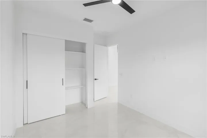 Bright interior featuring white walls and a white ceiling with a black ceiling fan