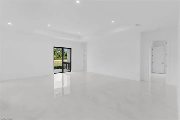 Spacious room featuring large format tile flooring, recessed lighting, and a neutral color palette