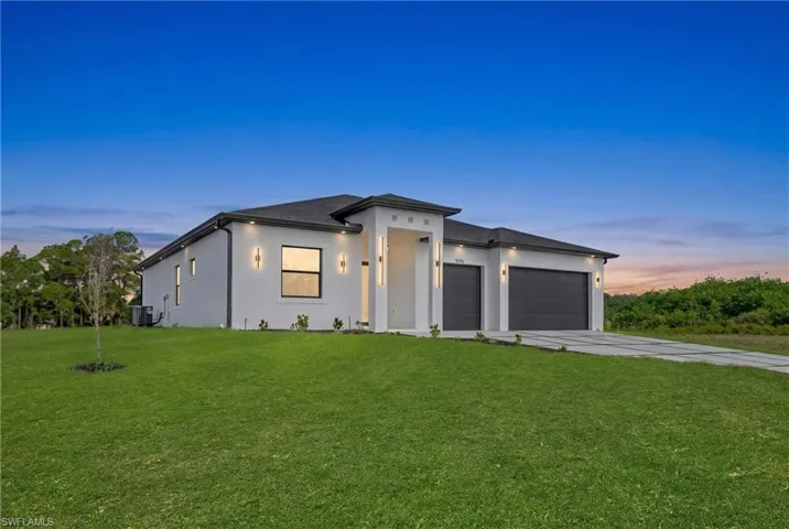 Contemporary stucco exterior featuring a dark asphalt shingle roof, two distinct dark garage doors, and a concrete driveway