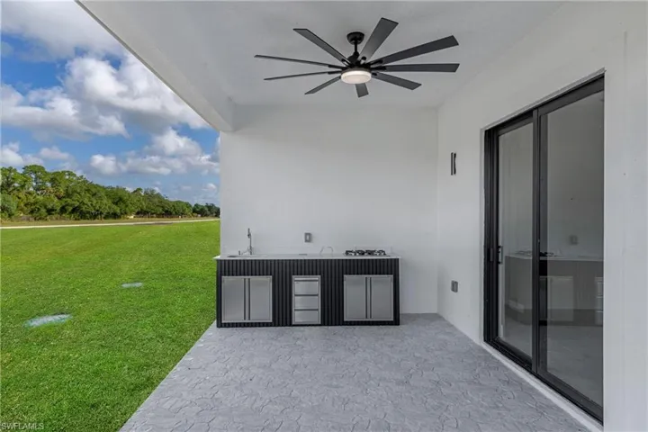 Outdoor patio featuring an integrated kitchen with a sink, cooktop, and built-in refrigeration