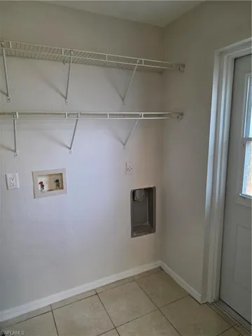 Laundry area with hookup for a washing machine and light tile patterned floors