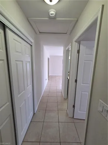 Hall with light tile patterned floors and baseboards