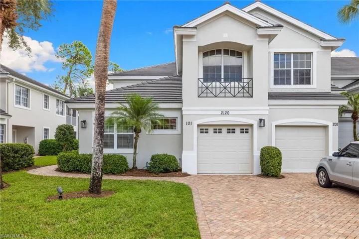 View of front of home with decorative driveway, stucco siding, a garage, and a front yard
