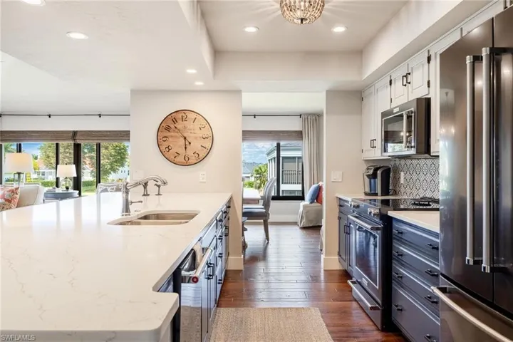 Kitchen featuring a wealth of natural light, sink, appliances with stainless steel finishes, and white cabinets