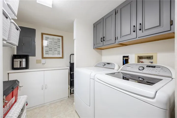 Washroom with cabinets, electric panel, and separate washer and dryer