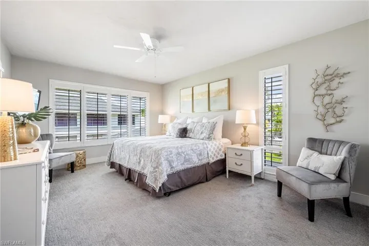 Bedroom with ceiling fan and light colored carpet