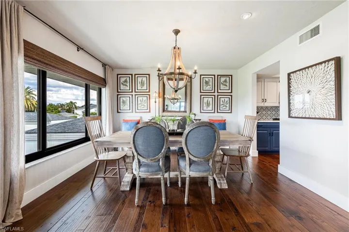 Dining space with dark wood flooring and a notable chandelier