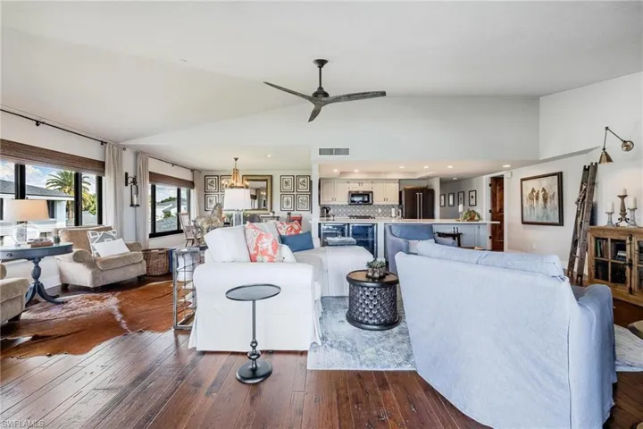 Living room with ceiling fan, lofted ceiling, and dark hardwood / wood-style floors