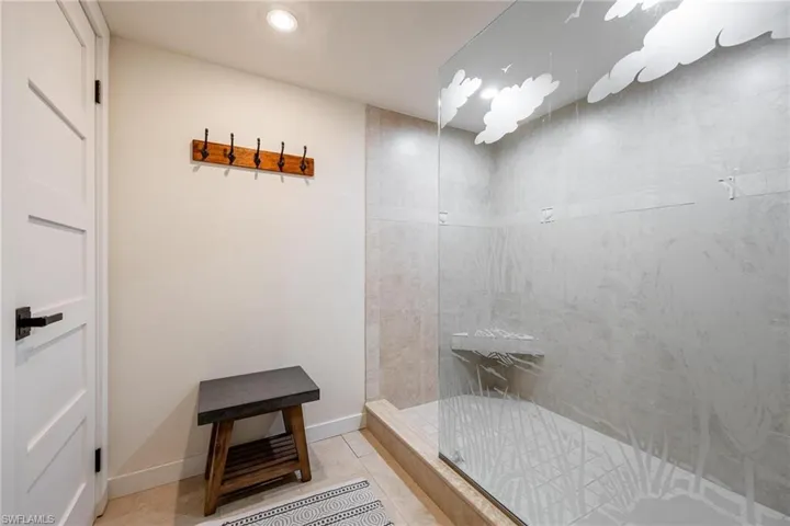 Bathroom featuring tiled shower and tile patterned floors