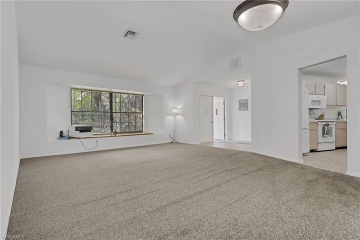 Spacious living and dining area with vaulted ceilings, window seat with storage, access to the kitchen, lanai, tons of natural lighting.