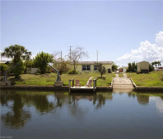 Dock area with a water view and a yard