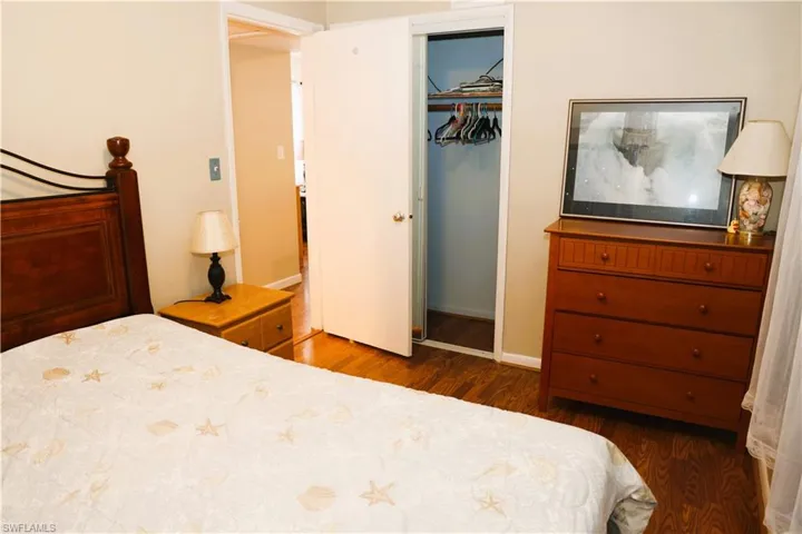 Bedroom featuring dark wood-type flooring and a closet